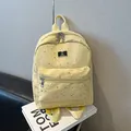 Mochila de lona amarillo claro con estampado de estrellas plateadas y bolsillo frontal - Amarillo