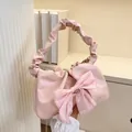 Nahaufnahme der rosa Faltenhandtasche mit großer Schleife und gerafftem Griff - Rosa