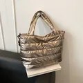 Bolso de mano acolchado en color oro champán con acabado metálico brillante y asas suaves - Dorado