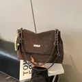 Détail d'un grand sac cabas marron en daim avec bandoulière chaîne et pendentif rétro en bois - Avec Pendentif / Marron