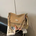 Gros plan sur un sac bandoulière camel mat avec garniture argentée et breloque perlée - Avec Pendentif / Kaki
