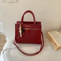 Borsa tote rossa con trama a spina di pesce, logo dorato e ciondolo in legno - Con Ciondolo / Rosso
