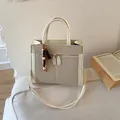 Dettaglio della borsa beige con trama a V e ciondolo decorativo con perline di legno - Con Ciondolo / Bianco
