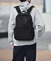 Classic black business backpack for men made of durable fabric on a male model - Black
