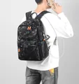 Black camouflage backpack with orange zippers and external USB charging port - Black