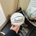 Detail of white basketball shaped mini bag with gold chain strap on black books - White