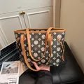 Dettaglio della grande borsa tote monogramma con stampa nera e tracolle in pelle marrone - Caffè Scuro