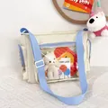 Detail of cute beige ita bag with clear window showing white plush bear and pins - Off White