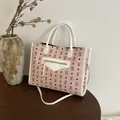 Bolso tote rosa y blanco con estampado de osos y correa ajustable sobre una mesa de madera - Rosa