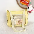 Close-up of yellow ita bag featuring a transparent PVC window and a white teddy bear inside - Yellow