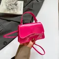 Mini borsa in pelle verniciata magenta con patta ondulata indossata da modella chic - Rosso rosa
