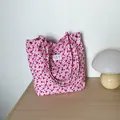 Detailansicht der rosa strukturierten Tragetasche mit Blumendruck und Metallnieten-Details - Rosa