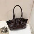 Dettaglio borsa tote in pelle verniciata marrone scuro con design increspato e manici - Marrone