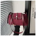 Detail of burgundy patchwork shoulder bag with suede texture and metal buckle - Red