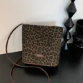 Detailansicht der Leopard-Beuteltasche mit Leder-Logo-Etikett und braunem Trageriemen - Braun
