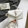Elegant white leather crossbody flap bag with a golden buckle and top handle - White