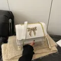 Sac à bandoulière blanc motif crocodile avec boucle papillon dorée et chaîne fine - Blanc