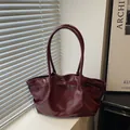 Minimalist deep burgundy patent leather bucket bag with pleated design and top handles - Red