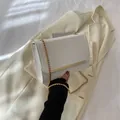 Elegant white crossbody chain bag with minimalist gold bar detail and matte faux leather - White