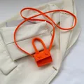 Mini bright orange felt crossbody bag with top handle and fine strap on white blazer - Orange