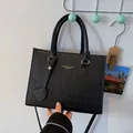 Bolso de mano negro acolchado con herrajes dorados y un colgante de corazón muy elegante - Negro