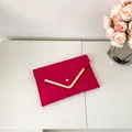 Elegant rose red envelope clutch with crocodile embossed texture and golden V-shaped trim - Rose Red