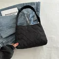 Minimalistische schwarze gesteppte Tragetasche mit Herzmuster und breitem Gurt - Schwarz