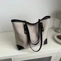 Bolso tote de lona beige minimalista con ribete de cuero negro y remaches de oro - Caqui