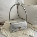 Sac baguette argenté métallisé avec boucle dorée sur fond en soie élégant - Argent