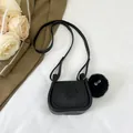 Mini black leather saddle bag with plush charm and debossed girl pattern detail - Black