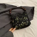 Sac seau noir avec broderie papillon dorée et poignée vintage en perles de bois - Noir