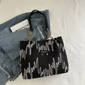 Sac cabas noir texturé orné de broderies vagues colorées et d'une étiquette logo en cuir - Noir