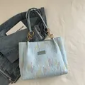 Sac fourre-tout matelassé bleu clair avec broderies colorées et bandoulière à chaîne dorée - Bleu