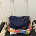 Sac bandoulière en toile bleu marine avec sangle rayée colorée et détails en cuir - Bleu foncé