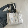 Sac cabas blanc matelassé avec broderies ondulées colorées et bandoulière chaîne dorée - Blanc