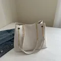 Borsa tote bianca a pieghe con rilievo FASHION e catena dorata in un ambiente moda - Bianco