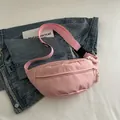 Pink nylon crossbody waist bag with adjustable strap and woven zipper pull detail - Pink
