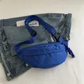 Blue nylon crossbody waist bag with adjustable strap and woven zipper pull detail - Blue