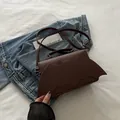 Deep brown leather bat-shaped shoulder bag with wing silhouette and top handle - Coffee