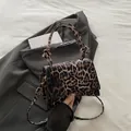 Chic leopard print crossbody bag with a unique knot handle and curved base design - Coffee Leopard