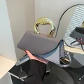 Fashionable gray handbag with textured flap and a unique gold-tone metal handle for women - Gray