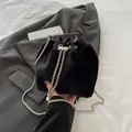 Black faux fur bucket bag with metallic chain strap and white pearl charm detail - Black