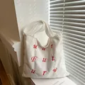 Minimalist ivory corduroy tote bag with red letter embroidery and wide shoulder strap - White