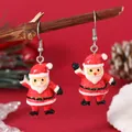 Close-up of glittery Santa Claus drop earrings hanging on a natural wooden branch - Waving Santa (EH5955)