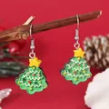 Detailed close-up of glittery green Christmas tree earrings hanging on a natural branch - Resin Xmas Tree (EH5958)