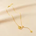 Elegant gold-tone snake chain necklace with interlocking double ring pendant and tassel bead - Double Rings / Gold