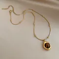 Macro view of gold snake chain with round beads and tiger eye stone teardrop pendant - Tiger's Eye Pendant Necklace