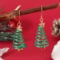 Detailed close-up of a Christmas tree spiral earring with gold star on a red backdrop - Spiral Xmas Tree (WEH3338)