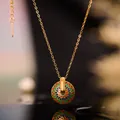 Macro shot of gold floral enamel pendant necklace with colorful inlay on dark reflective surface - Enamel Flower Necklace