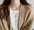 Detail of adjustable gold pearl Y-necklace showing the drop pendant on a white sweater - Gold Adjustable Artificial Pearl Necklace